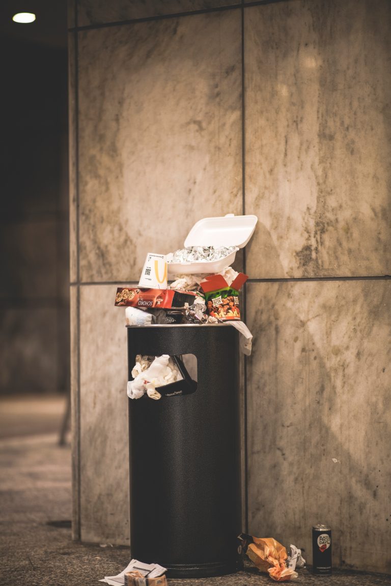 overflowing trash bin to portray waste