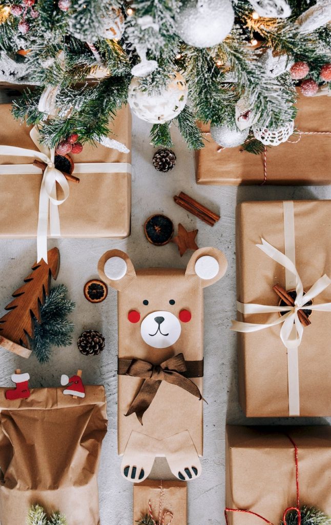 christmas gifts wrapped under tree with brown paper