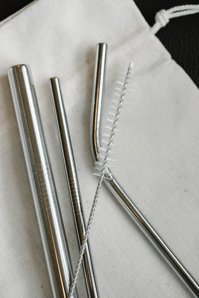 three metal straws with a straw cleaner
