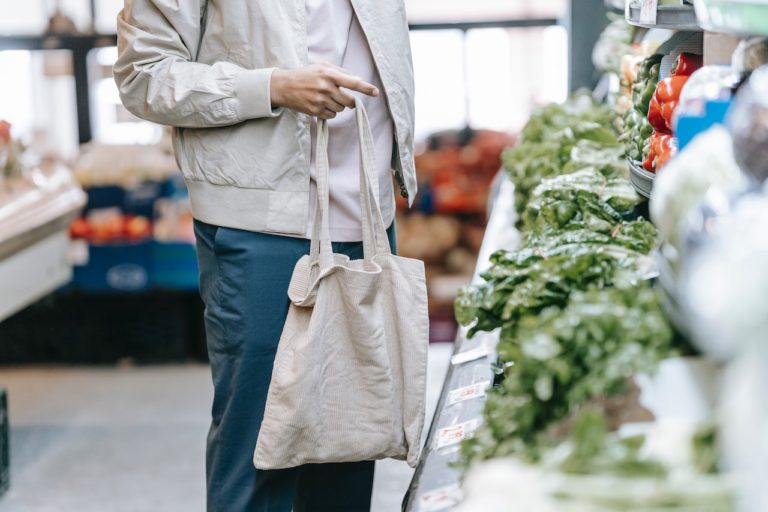 cotton reusable tote held by man shopping in produce section