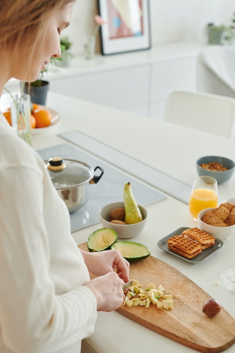 woman preparing food in kitchen on cutting board