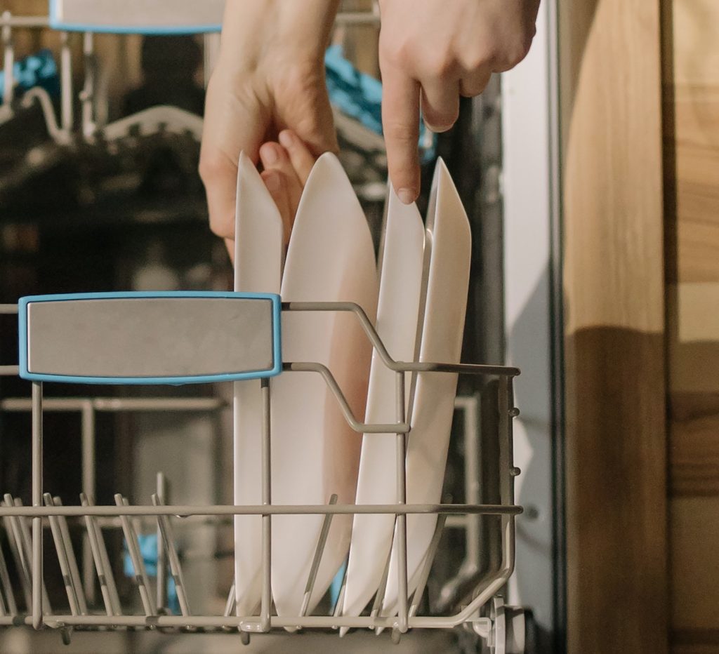 dishwasher being loaded with dishes