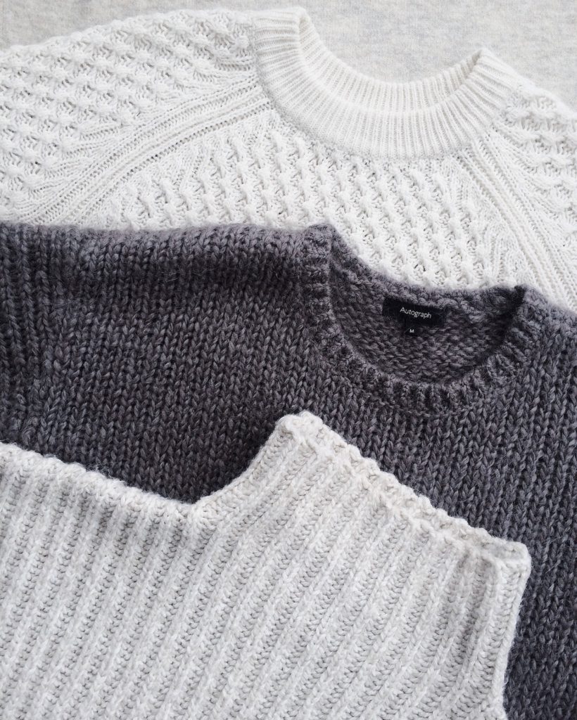 3 sweaters on top of each other in following order: white, grey, white