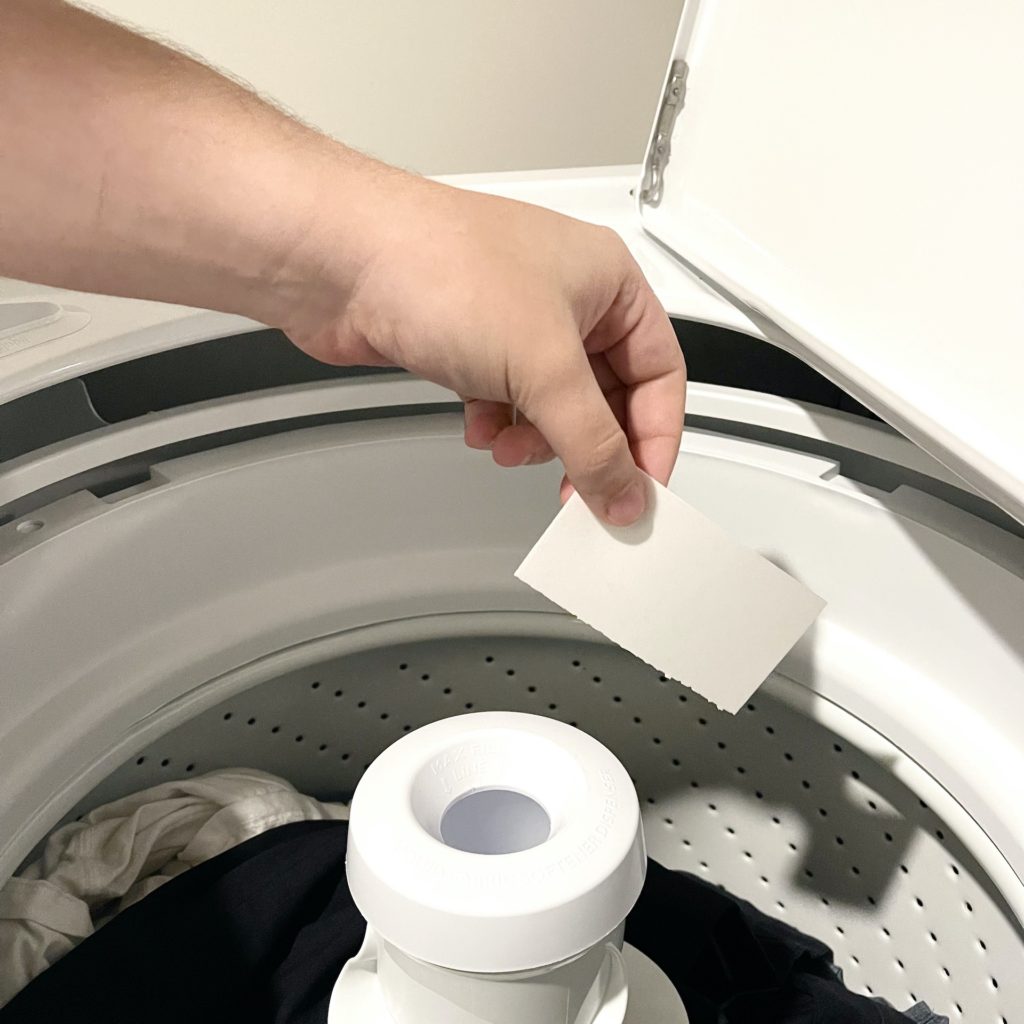 Tru Earth detergent sheet being placed in washer