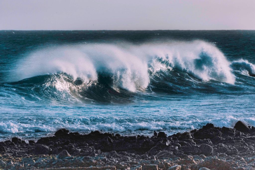 waves crashing giving off ocean mist that carries microplastics